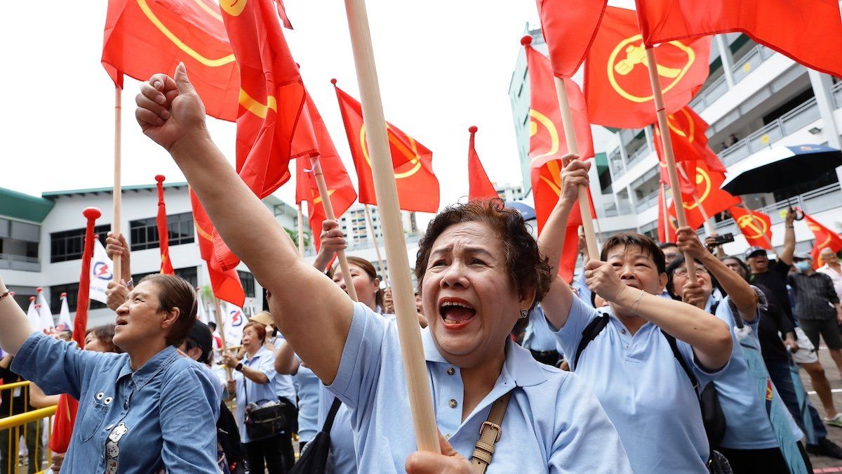 ​Workers' Party (WP) supporters wave party flags as they cheer their candidates at the nomination center ahead of the general election in Singapore, on April 23, 2025. 