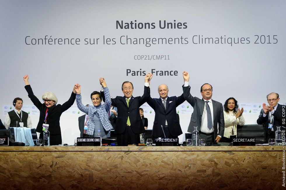 World leaders celebrate the adoption of the Paris Agreement at COP21 in 2015.