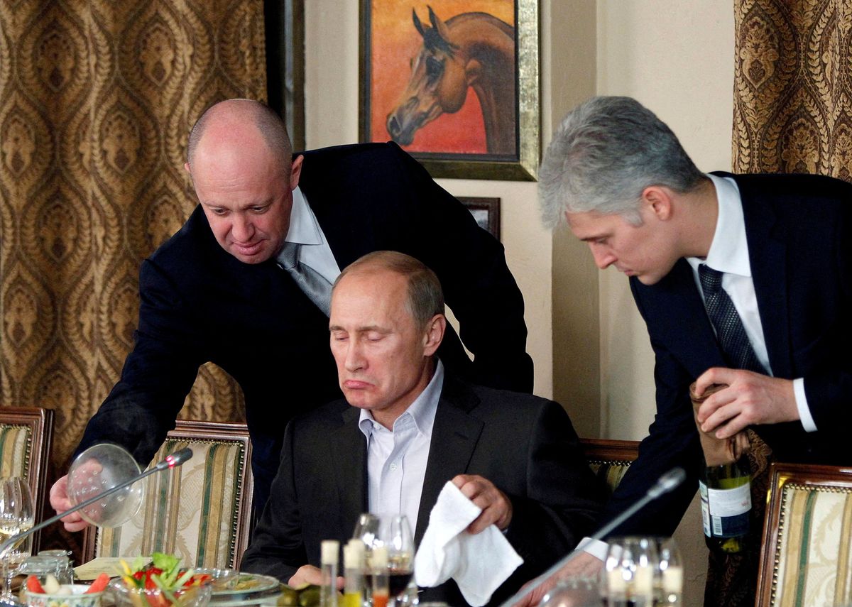 Yevgeny Prigozhin, left, serves Vladimir Putin dinner at a Moscow restaurant in 2011.
