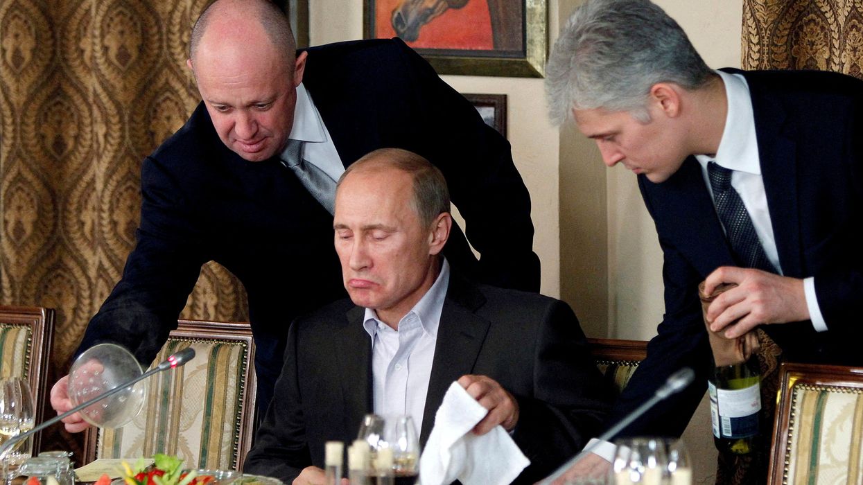 Yevgeny Prigozhin, left, serves Vladimir Putin dinner at a Moscow restaurant in 2011.